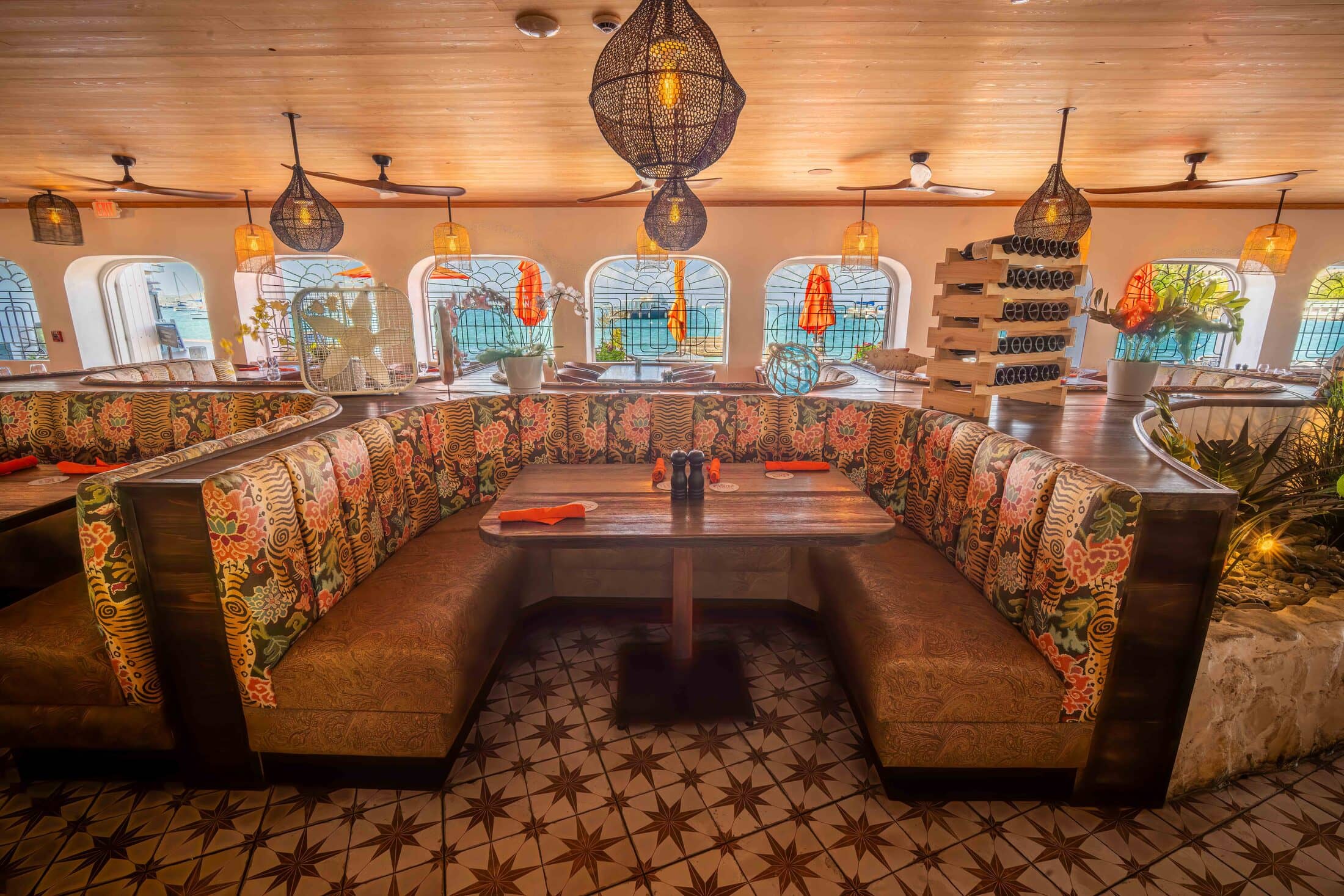 Curved banquette booth beneath woven pendant lights at Harbour Prime
