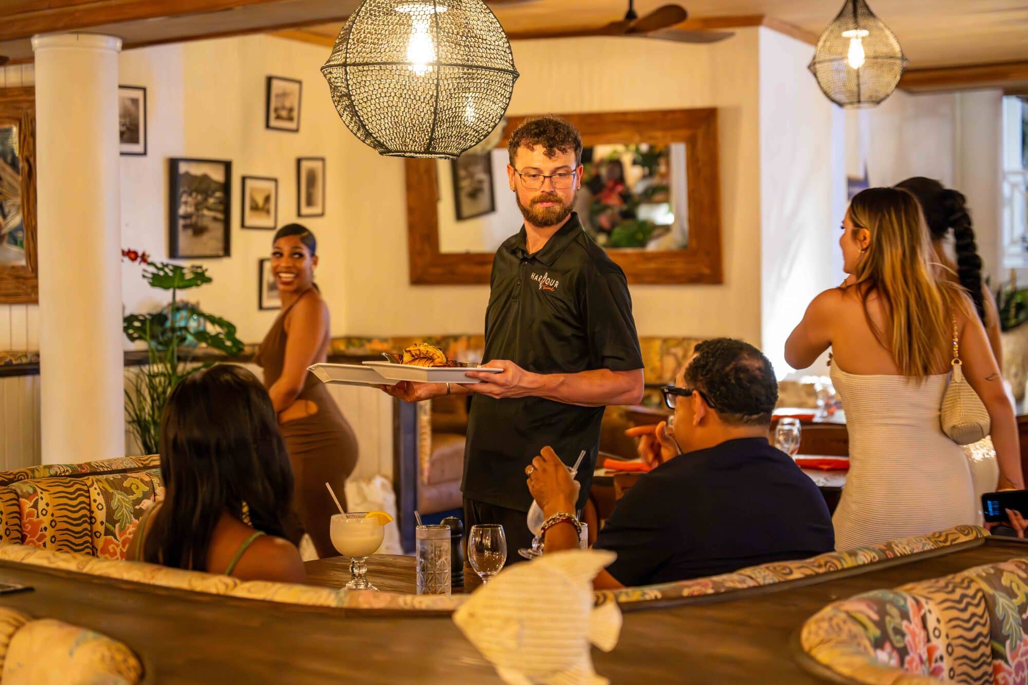 A server delivering dinner to guests at a waterfront table at Harbour Prime